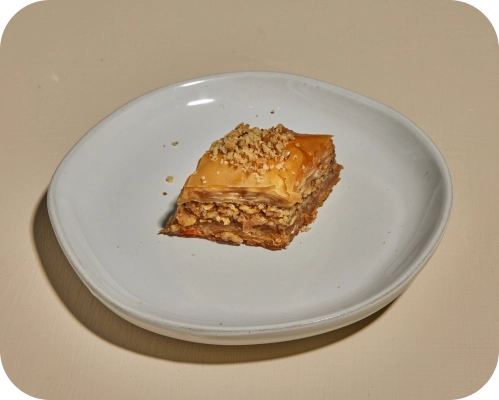 Blue plate with piece of baklava in the center.