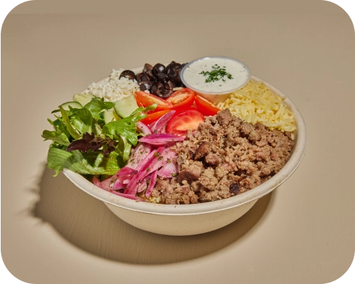 Beef and lamb, lettuce, tomatoes, cucumbers, in a Mediterranean rice bowl.