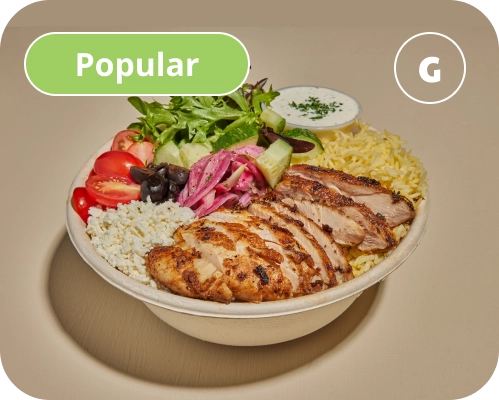 Chicken, vegetables, and sauces inside of a Mediterranean rice bowl.