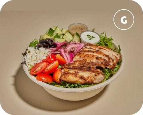 Chicken shawarma, sauces, and vegetables in a Mediterranean salad bowl.