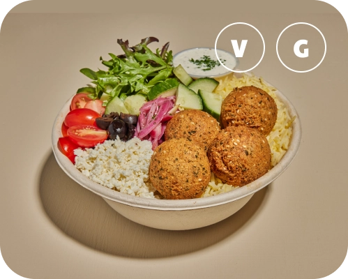 Falafel, vegetables, and sauce in a Mediterranean rice bowl.