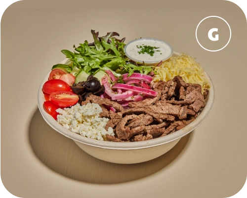 Steak shawarma, vegetables, and sauce in a Mediterranean rice bowl.